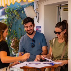 People signing up for an event outdoors, creating a lively atmosphere.